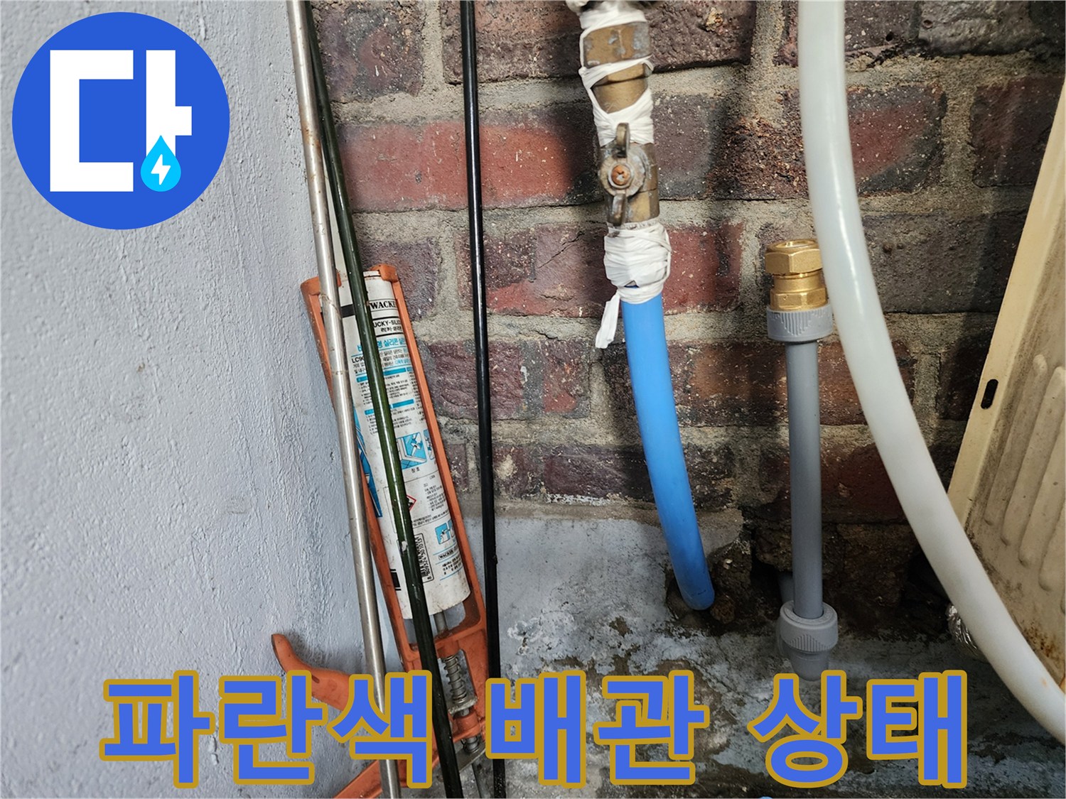 벽돌 벽면에 노출된 파란색 PB 배관과 연결 부위 모습