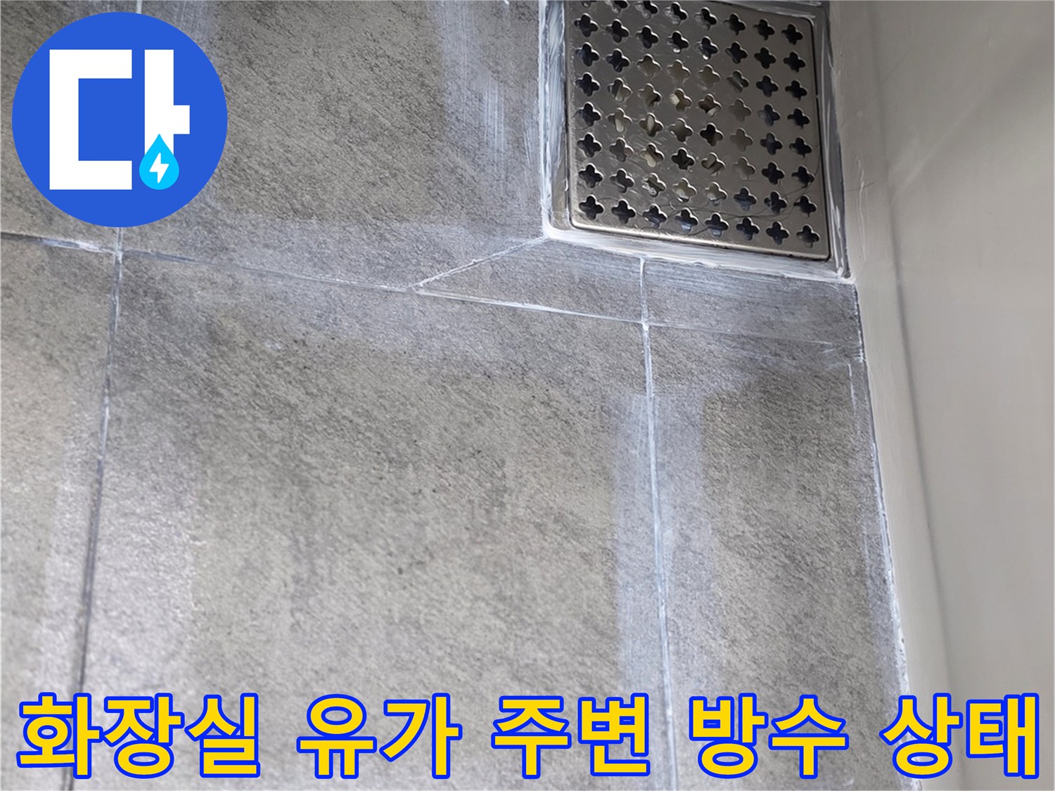 화장실 바닥 배수구 유가 주변의 타일 마감 상태를 보여주는 사진입니다.