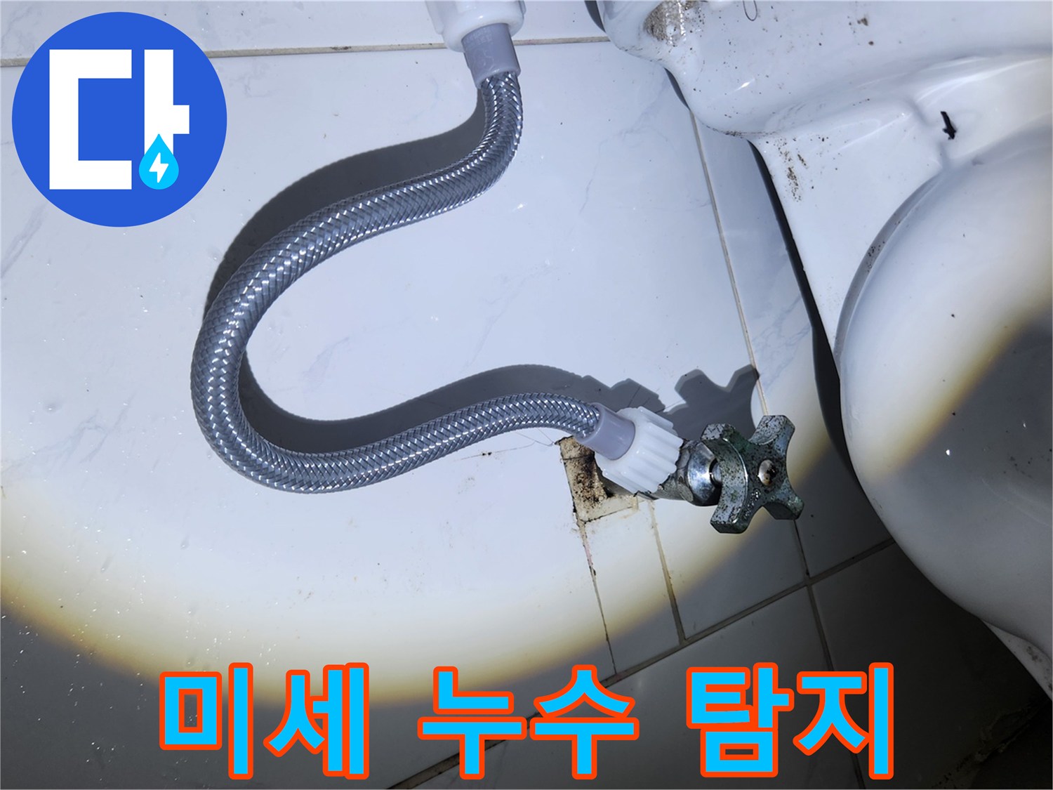 손전등 빛 아래-오래된 변기 앵글 밸브와-급수 호스 연결 부위에서-미세한 누수 흔적을-탐지하는 모습입니다