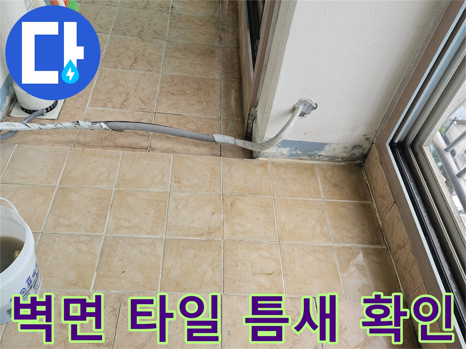 아파트 베란다 벽면 타일 사이의 오염과 습기 상태를 근로자가 점검 중인 장면