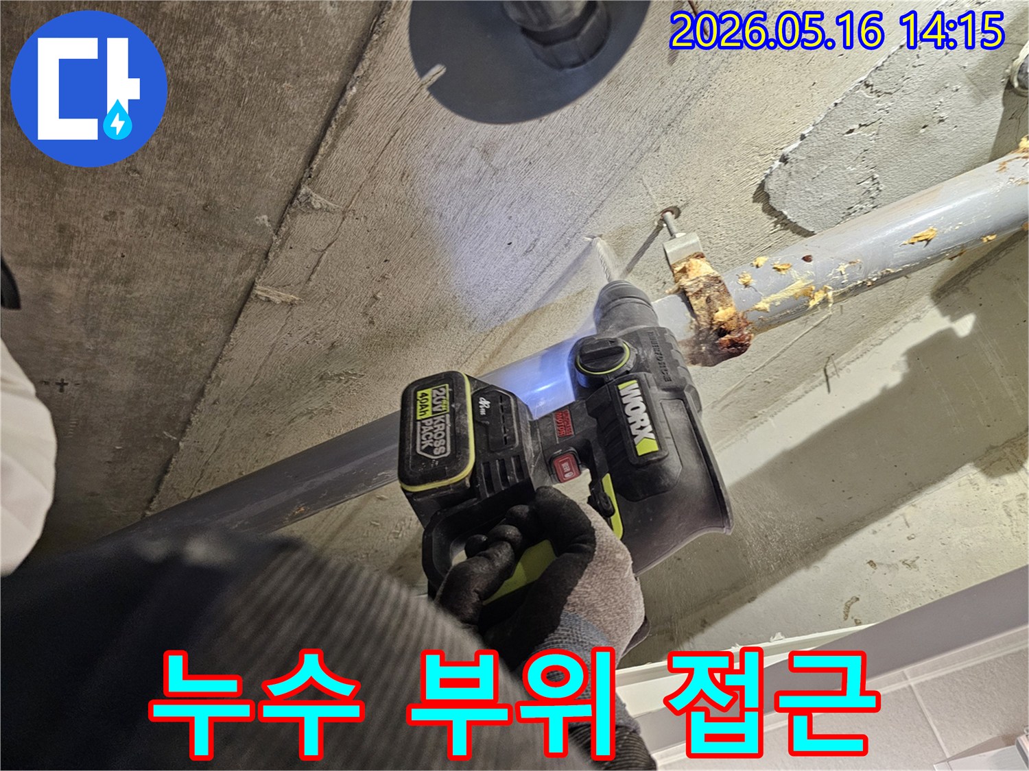 누수 전문가가 천장 배관의 누수 부위에 접근하기 위해 드릴로 콘크리트를 타공하는 모습-정확한 누수 보수를 위한 필수 단계입니다.