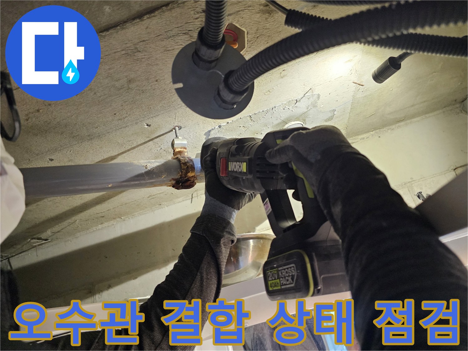 천장 내부 오수관의 연결 부위를 전동 드릴로 면밀히 조사하는 장면