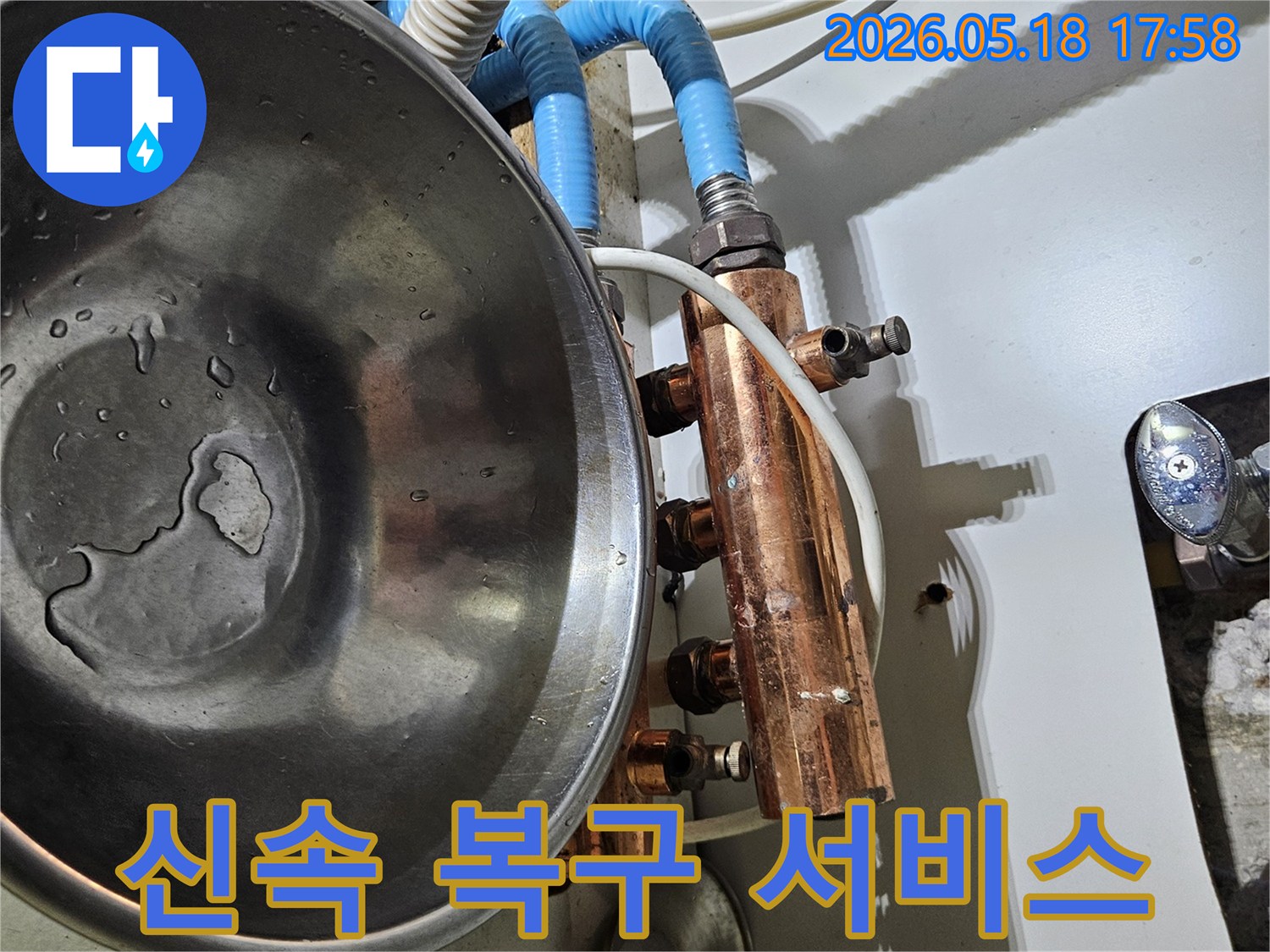 보일러 분배기에서 발생한-누수를 확인하고-신속한 복구를 위해-물이 새는 것을 받아내는-작업 현장 이미지입니다.
