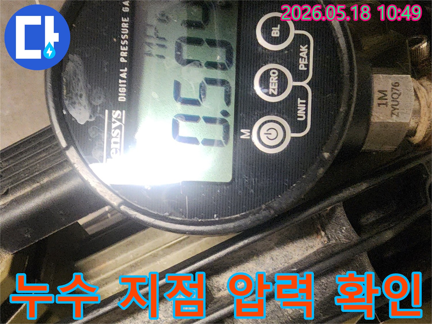 누수 엔지니어가 디지털 압력계를 사용하여 배관 시스템의 압력 변화를 정밀하게 모니터링하여 누수 지점을 확인하는 장면