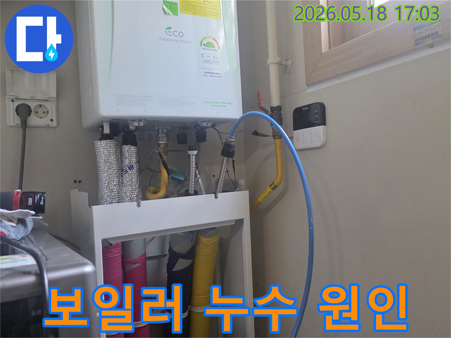 보일러 하단부의 배관 연결 상태를-면밀히 검토하여-누수 원인을 파악하는 장면입니다.