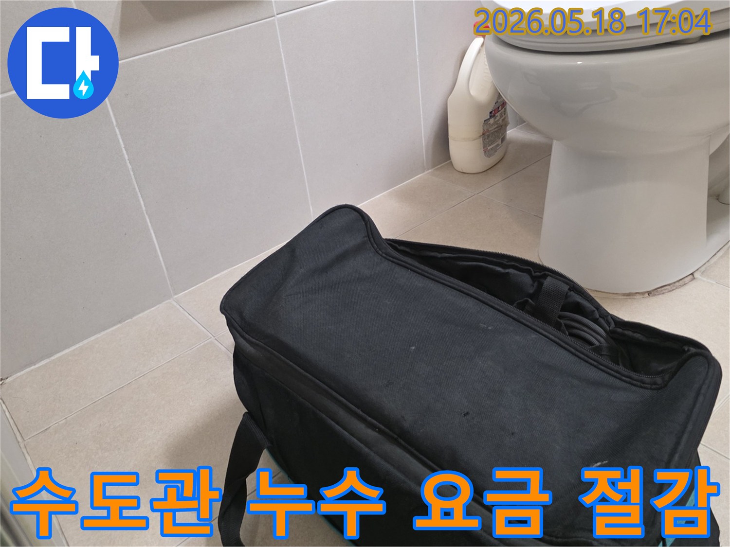 전문가가 구산동 빌라 화장실에서-수도관 누수 확인으로 수도 요금 절감을 위해-탐지 장비를 준비하는 장면입니다