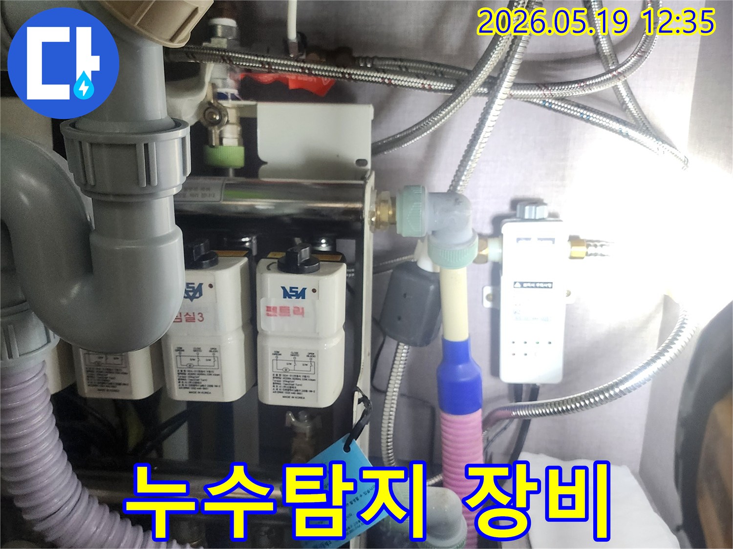 누수 원인을-찾기 위해-설치된-복잡한 배관과-정수 시스템을-전문가가-점검하는-현장 사진입니다.