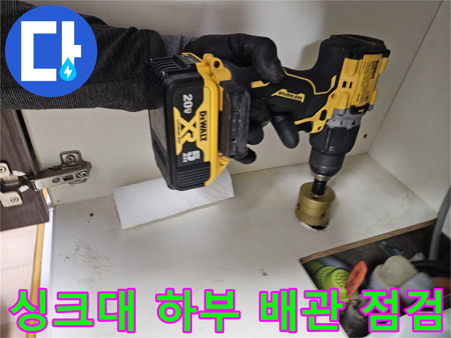 전동 드릴을 이용한 싱크대 하단 배관 부위의 세밀한 검사 과정