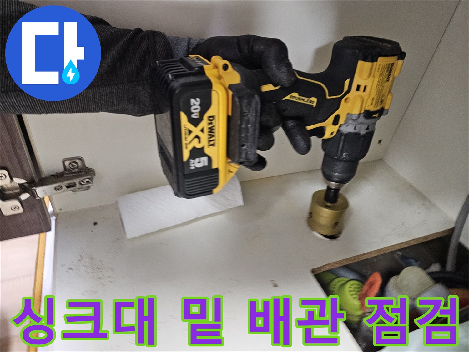 전동 장비를 사용하여 싱크대 하부의 누수 부위를 탐지하는 장면