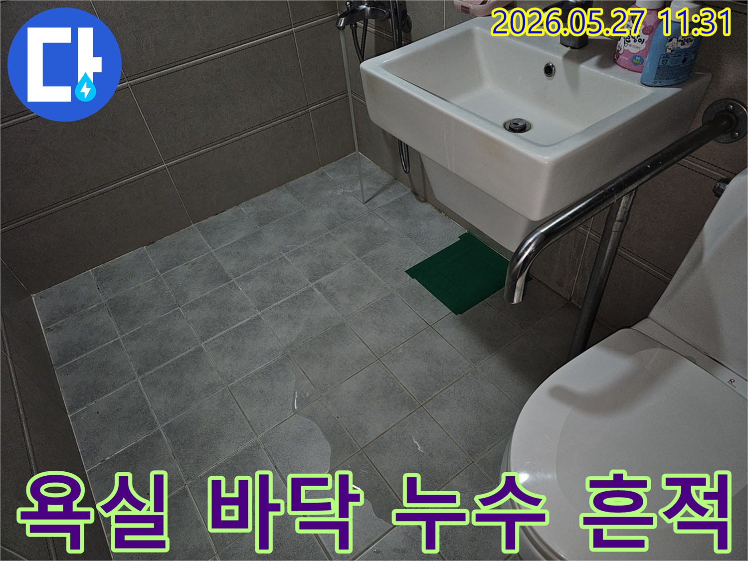 욕실 바닥에 물이 고여 있는-누수 현장을 보여주는 사진입니다.