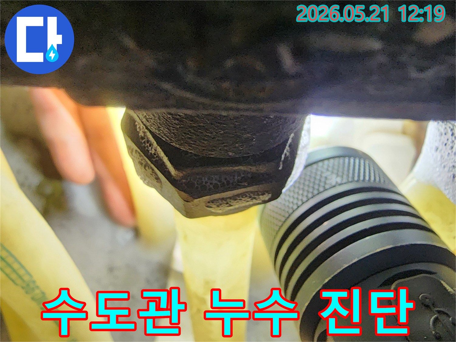 플래시를 이용해-어두운 수도관의-연결 부위를-밝혀-누수 여부를-세밀하게 진단하는-전문가의 시선