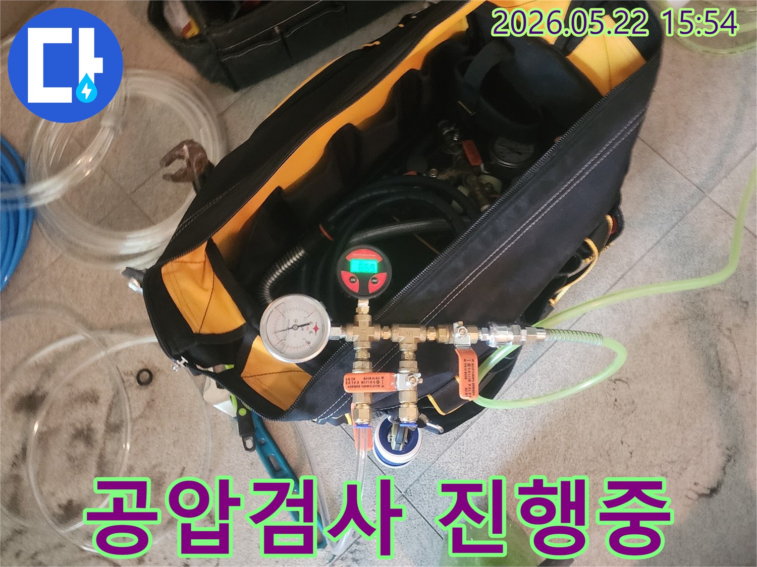 누수-탐지-전문가가-공압-검사-장비로-배관-압력을-확인하는-모습