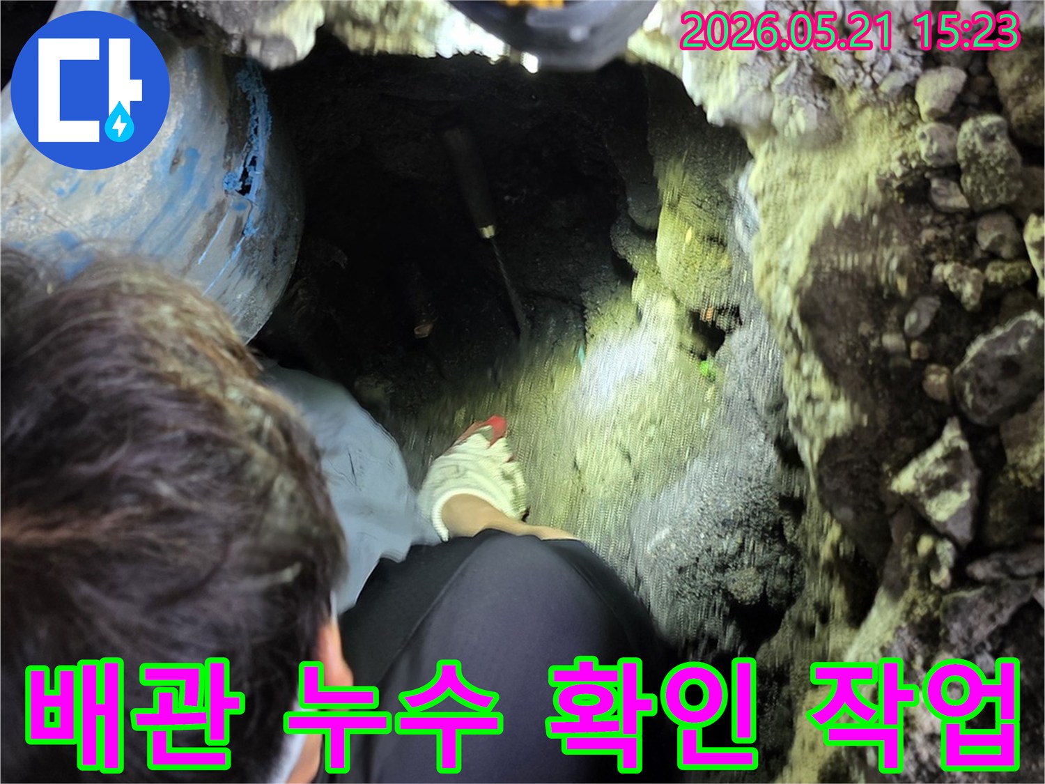 전문 엔지니어가 어두운 지하 공간에서-손전등을 이용해-배관 누수 지점을 정밀하게 탐지하는 모습입니다.