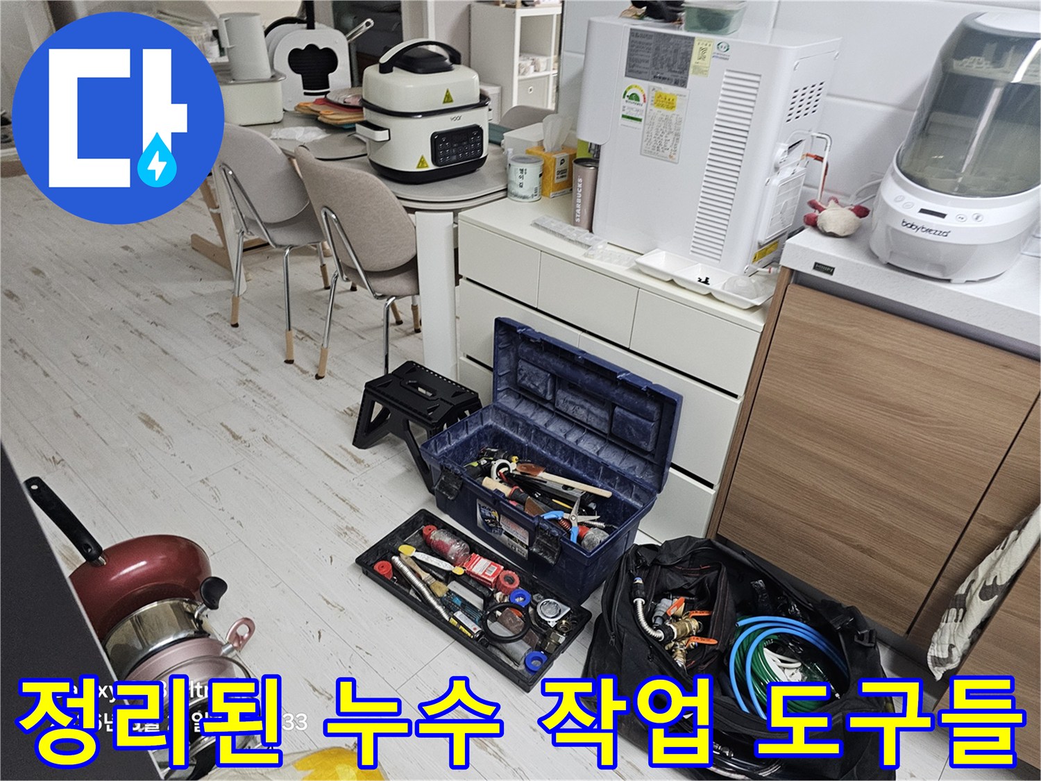 싱크대 하단 배관 점검을 위해 배치된 다양한 종류의 수공구와 장비