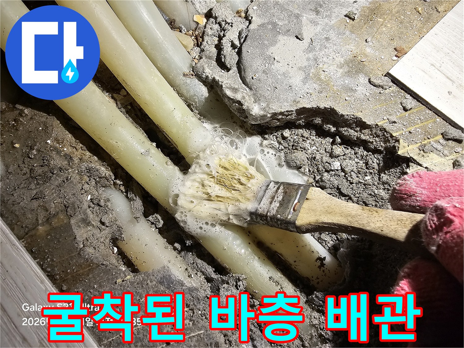 콘크리트 파쇄 후 드러난 노출 배관과 젖은 흙
