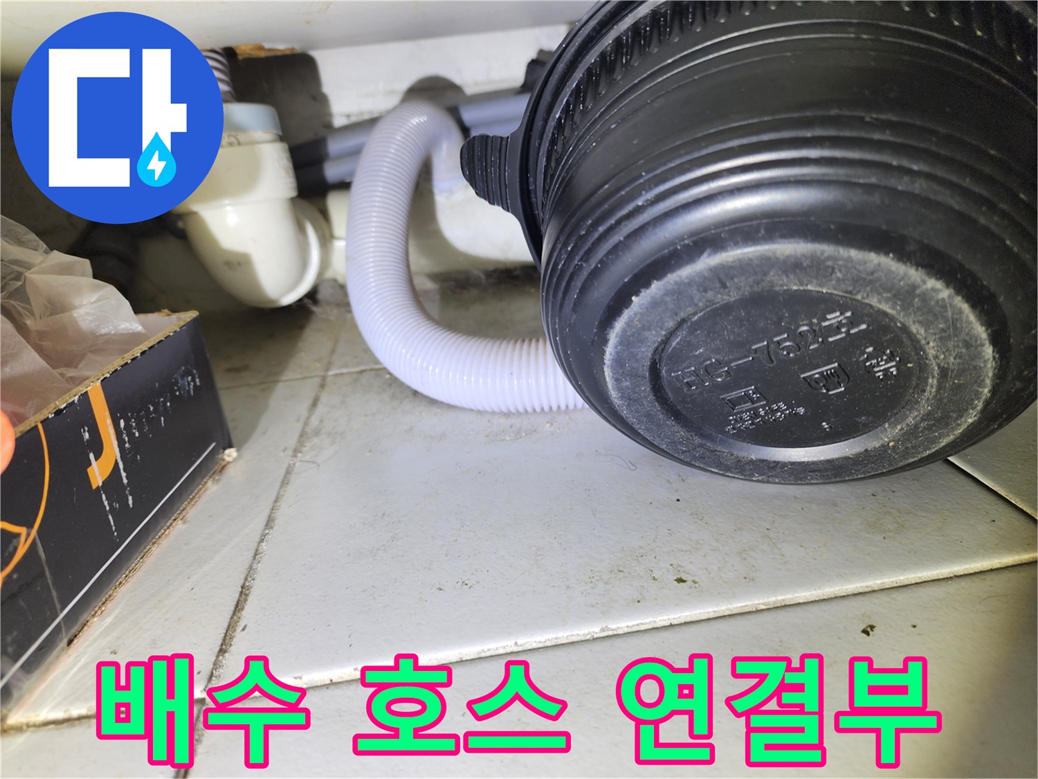 하얀색 배관과 검은색 장비 사이의 자바라 호스 설치 상태입니다.