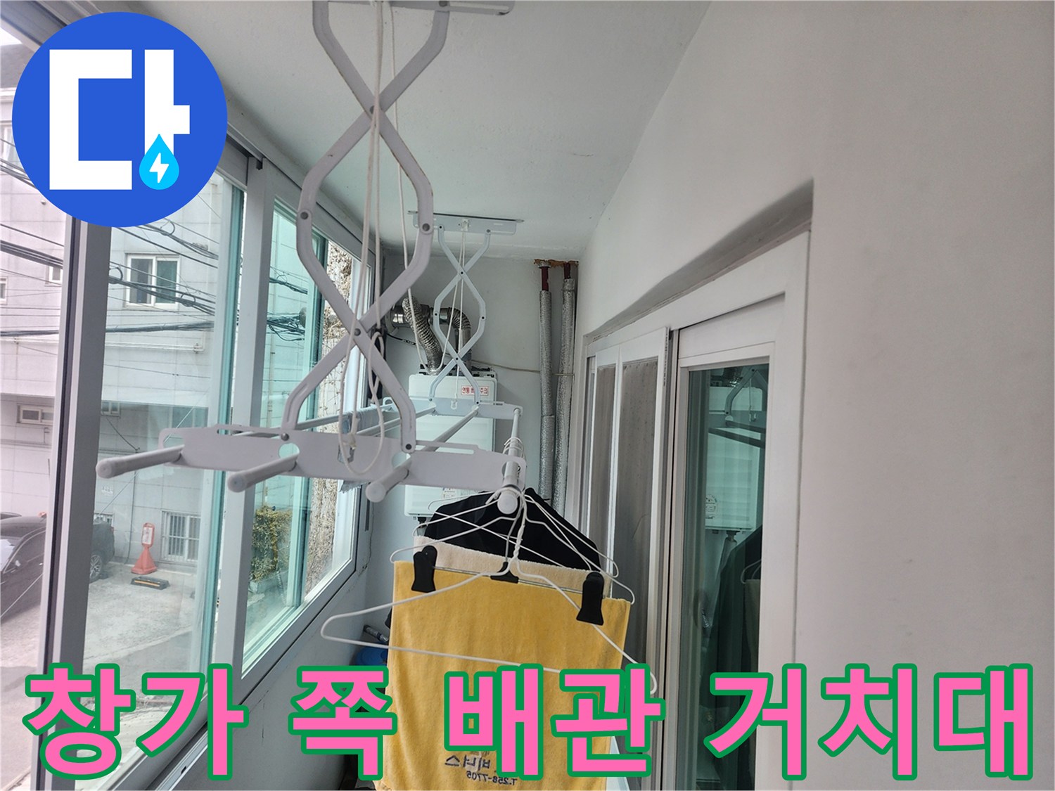 흰색 프레임으로 된 배관 지지 구조물과 창문 밖 풍경입니다.