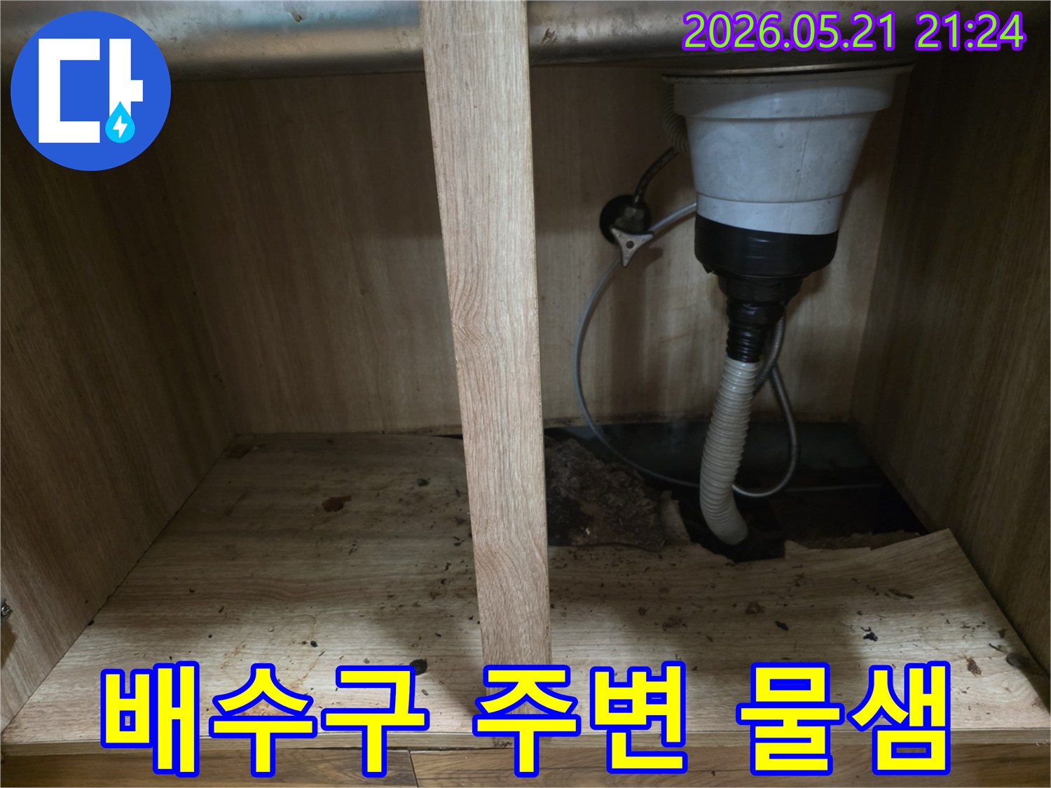 싱크대 하부 배수구 연결 부위에서-물이 새어 바닥 합판이 젖어있는-누수 현장 사진