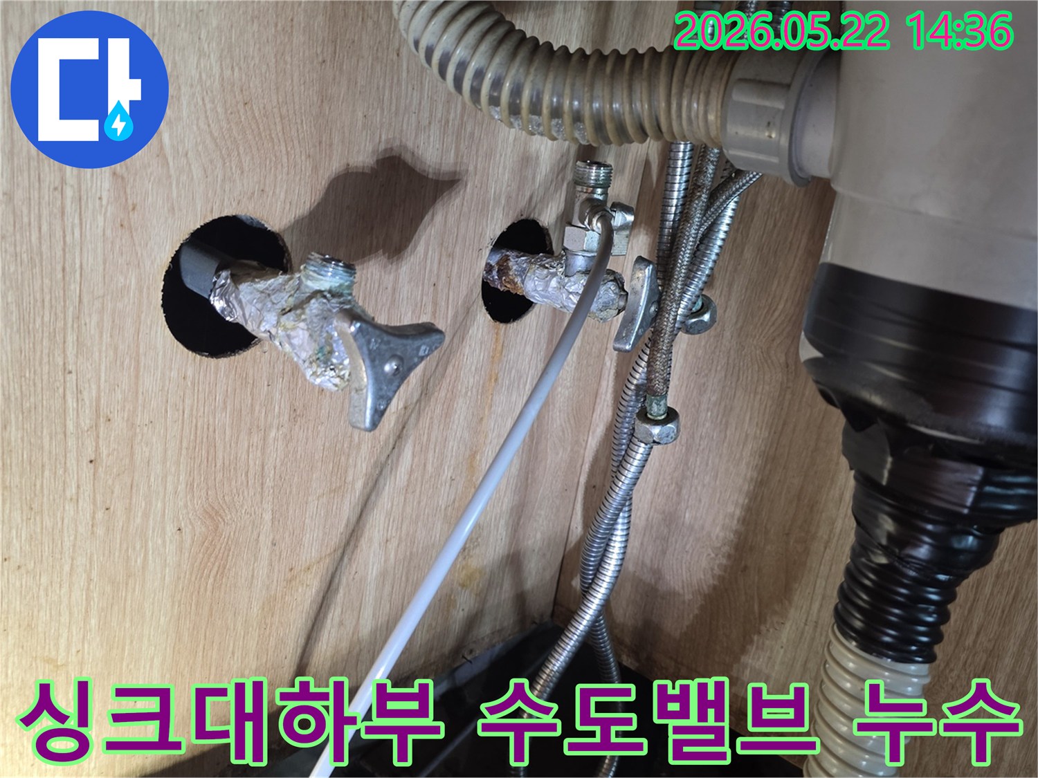 싱크대 하부에서 수도 밸브-배관 연결 부위의 부식으로 인한 누수 현장을 보여주는 이미지입니다