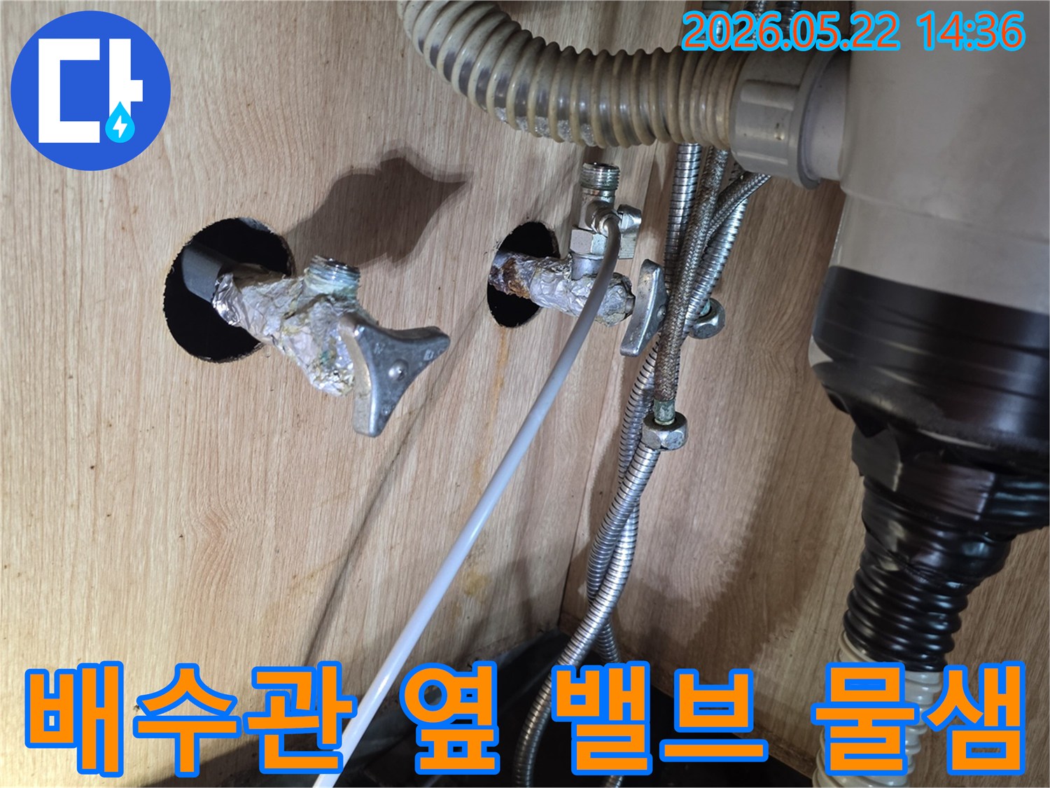 싱크대 하부의 배수관 옆에 위치한 수도 밸브에서 물이 새어 나오는 현장입니다