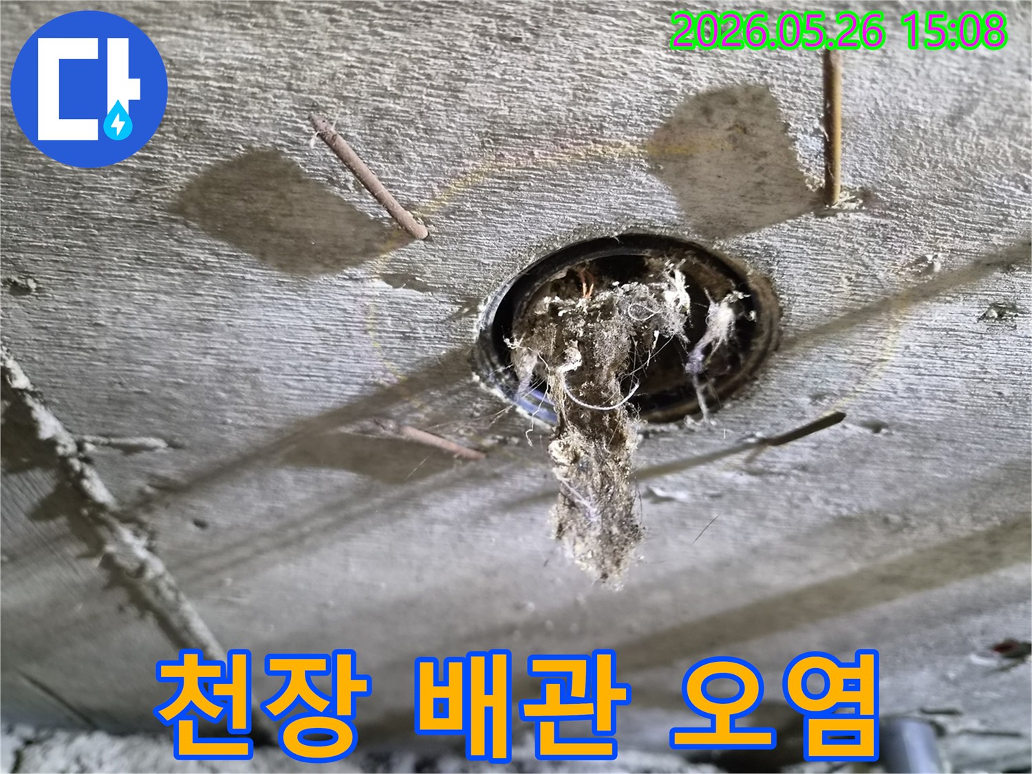 콘크리트 천장 구멍에서-배관 문제로-인해-오염된 이물질이-떨어지는-누수-현장의-상황을-보여주는-사진