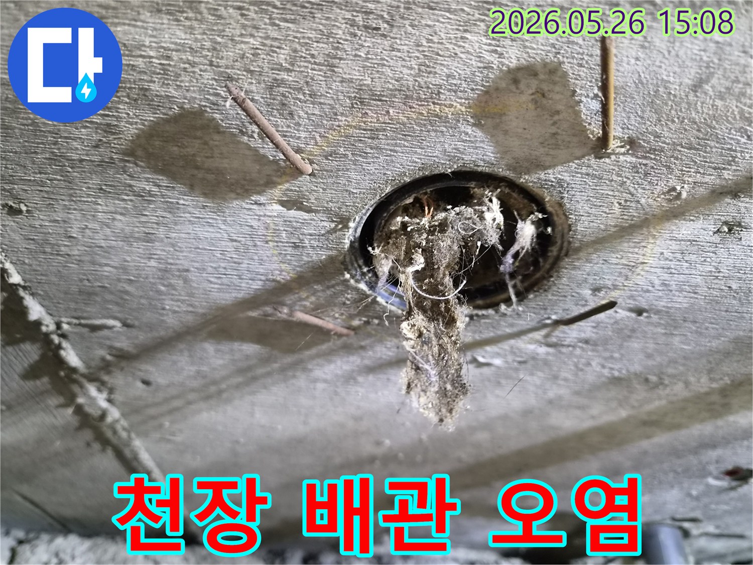 콘크리트 천장 구멍에서-배관 문제로-인해-오염된 이물질이-떨어지는-누수-현장의-상황을-보여주는-사진