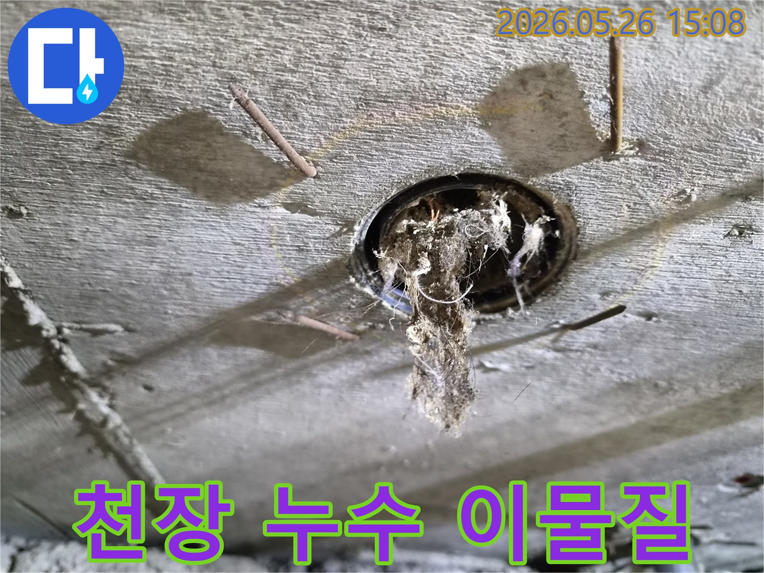 콘크리트 천장 구멍에서-오래된 이물질과-곰팡이가-떨어지는-모습을-보여주는-누수-현장-사진