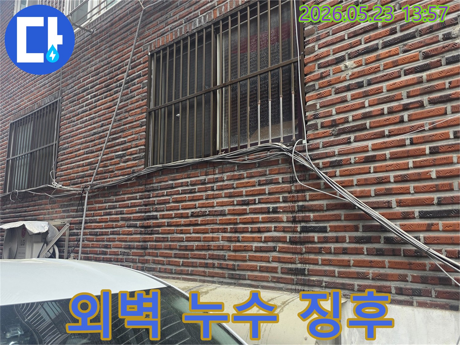 벽돌 외벽에-누수로 인한-검은 물자국이 보이는-주택 외부의 모습입니다.