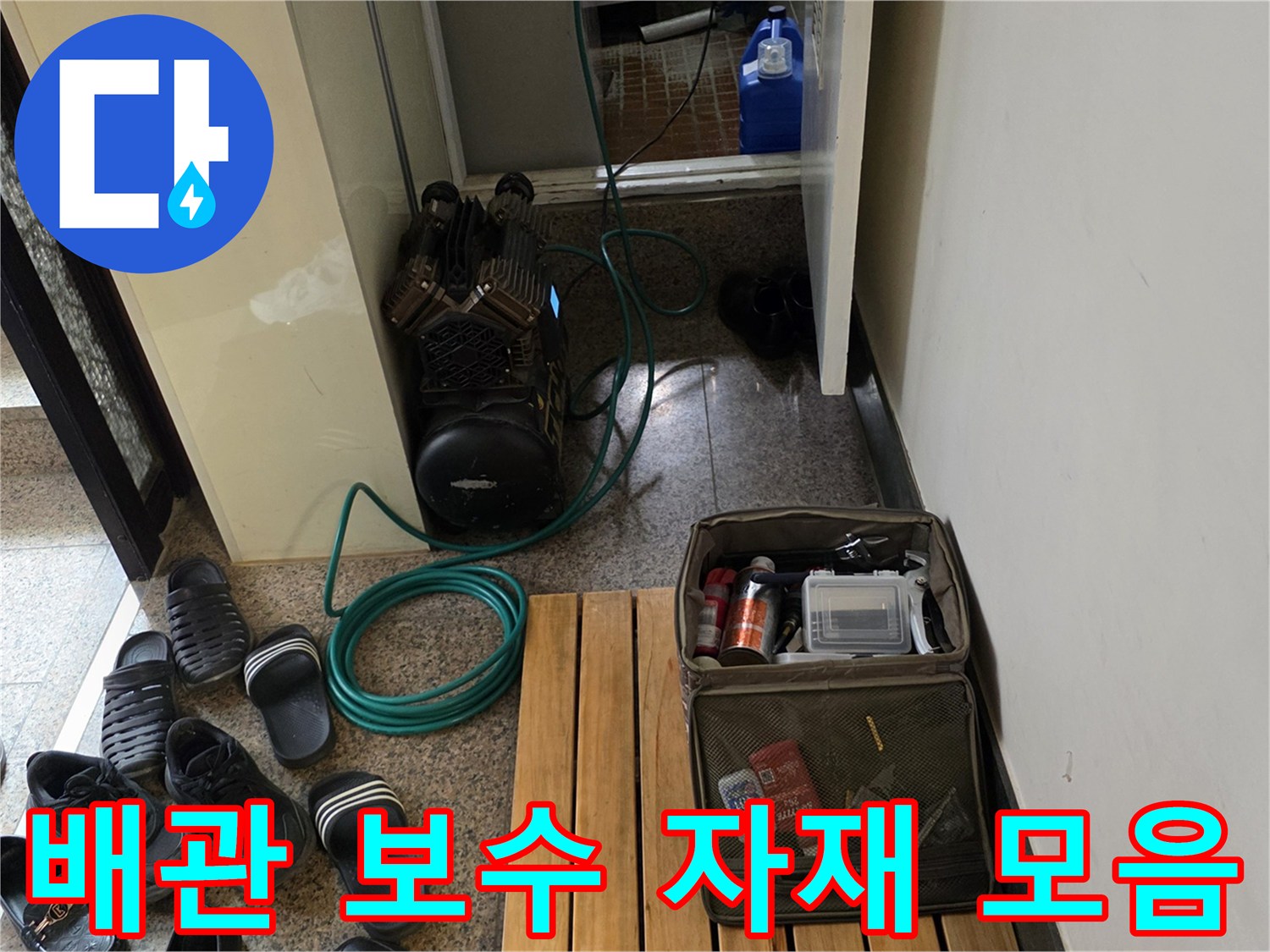 작업 현장 바닥에 놓인 컴프레셔와 배관 수리용 소모품 상자