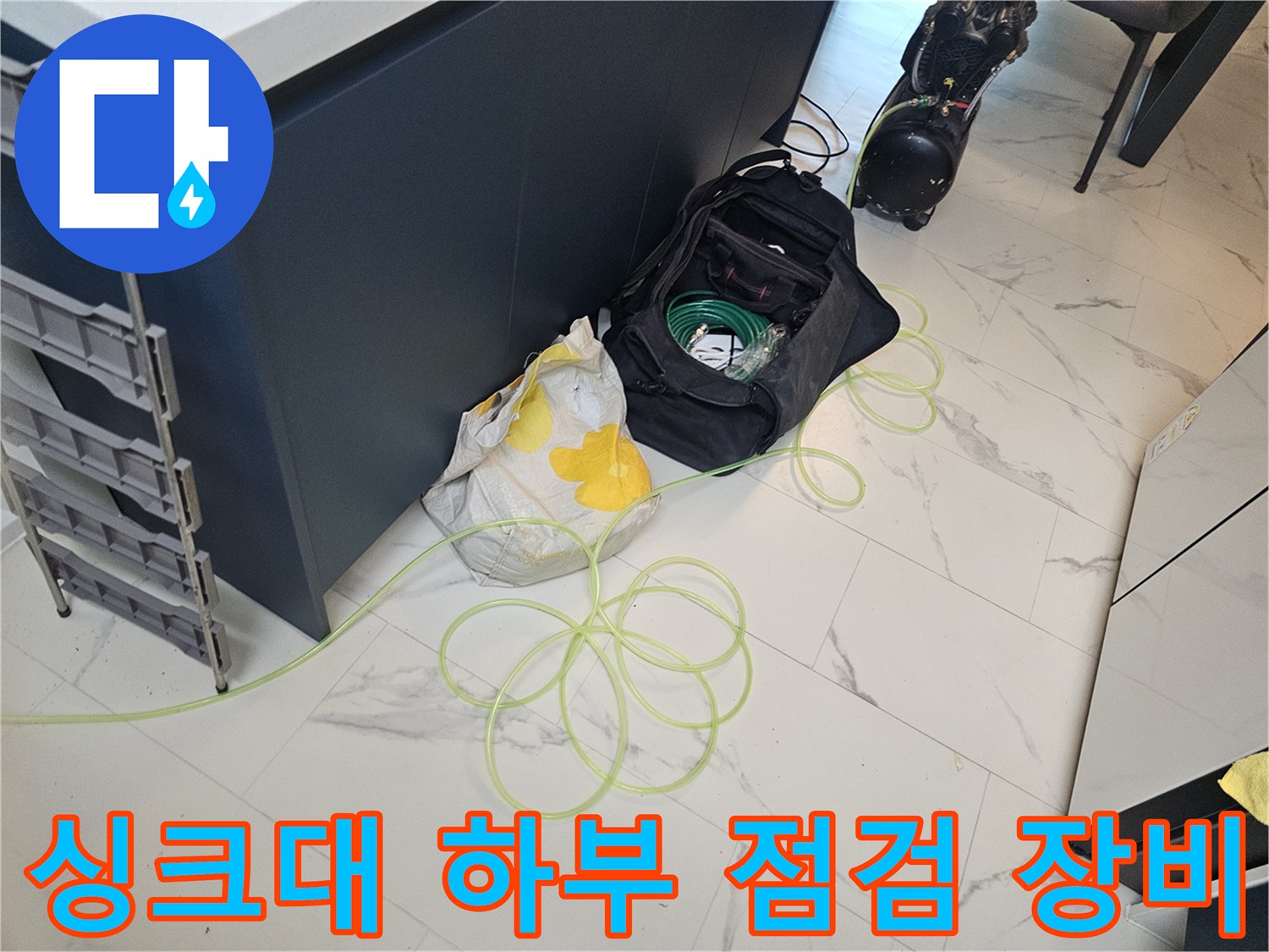 싱크대 하부장에 놓인 누수 탐지용 장비와 자재들