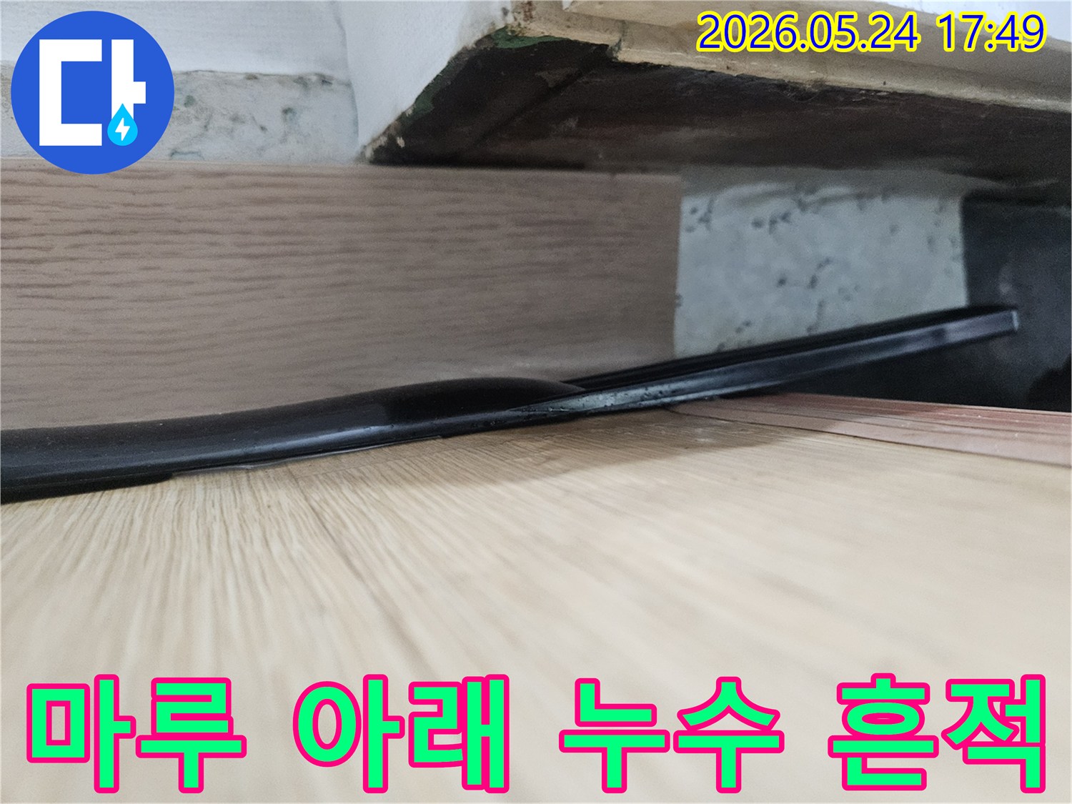 오래된 마루 아래에서-발견된 누수로-인한 물기 흔적과-손상된 배관의 모습