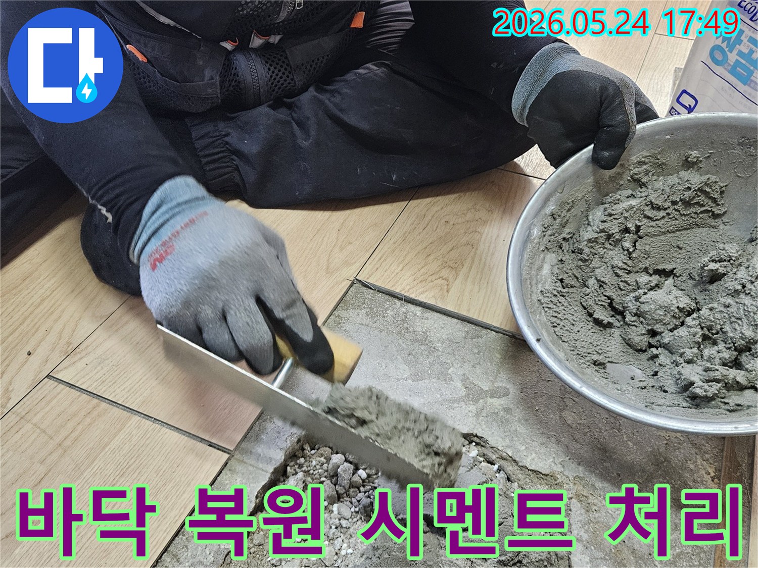 작업자가 보호 장갑을 착용하고 흙손으로 시멘트 혼합물을 바닥에 고르게 펴 바르는 모습-누수 수리 후 바닥면을 평평하게 만드는 중요한 단계