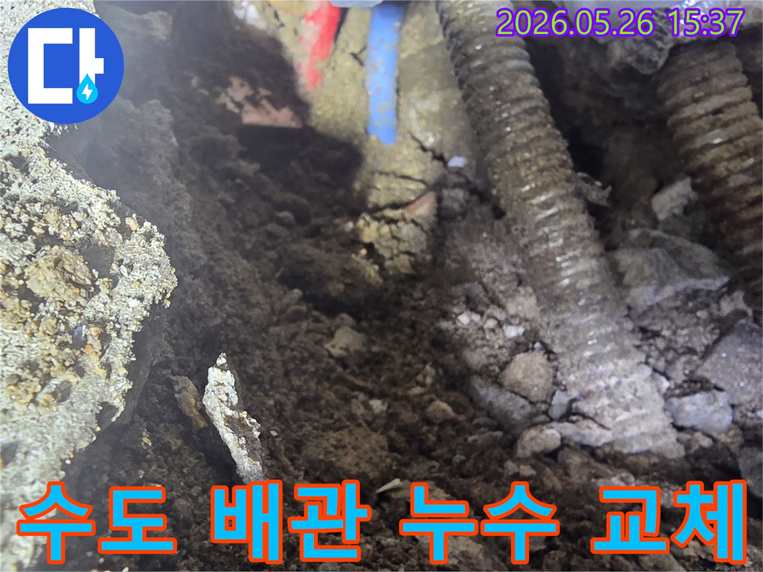 이 이미지는 우이동 주택의 땅속에 매설된 수도배관에서 누수가 발생하여 굴착 후 교체 작업이 진행되는 현장을 보여줍니다.