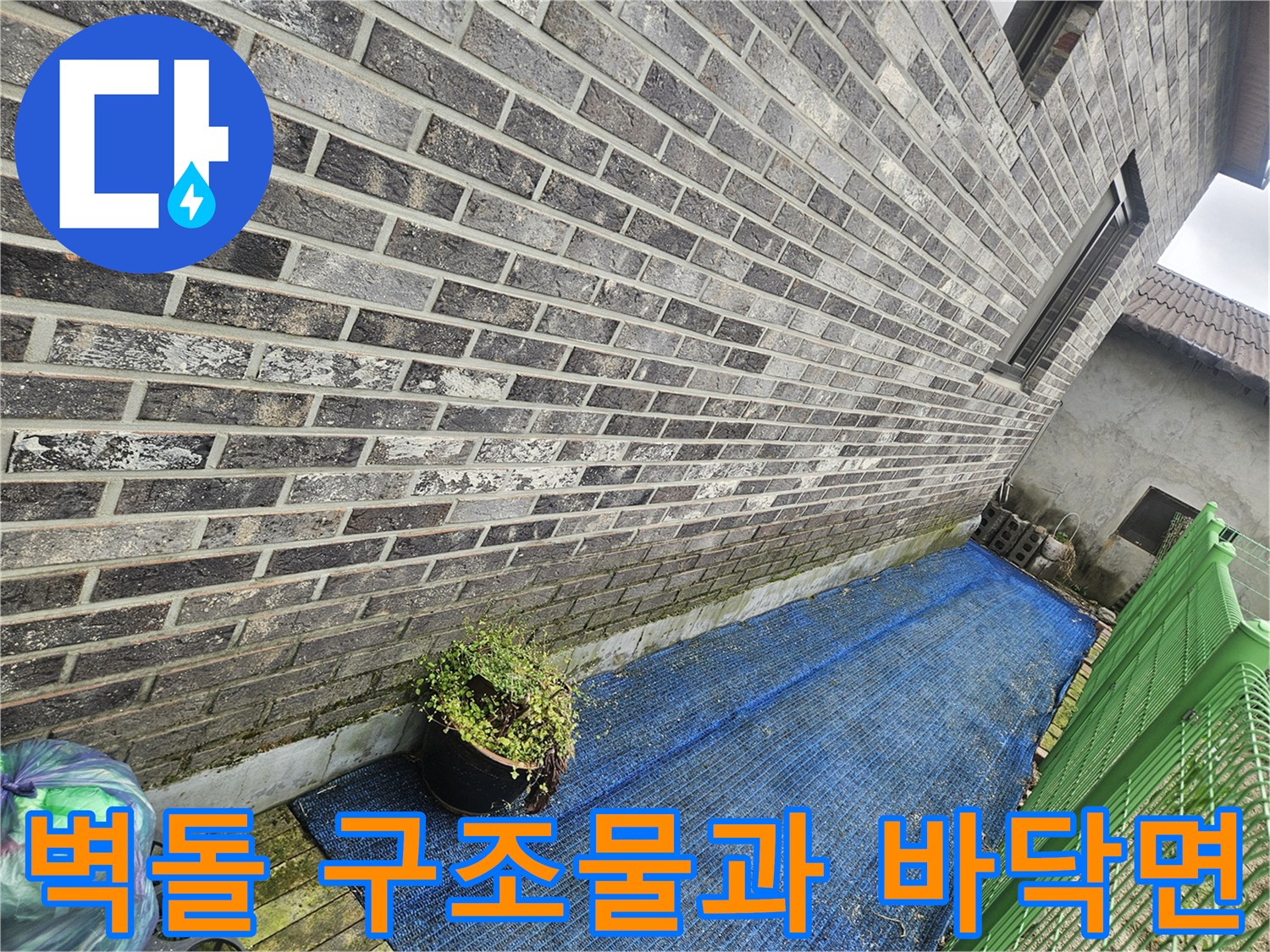 배관 수리를 위해 조사 중인 주택 외벽 벽돌 담장