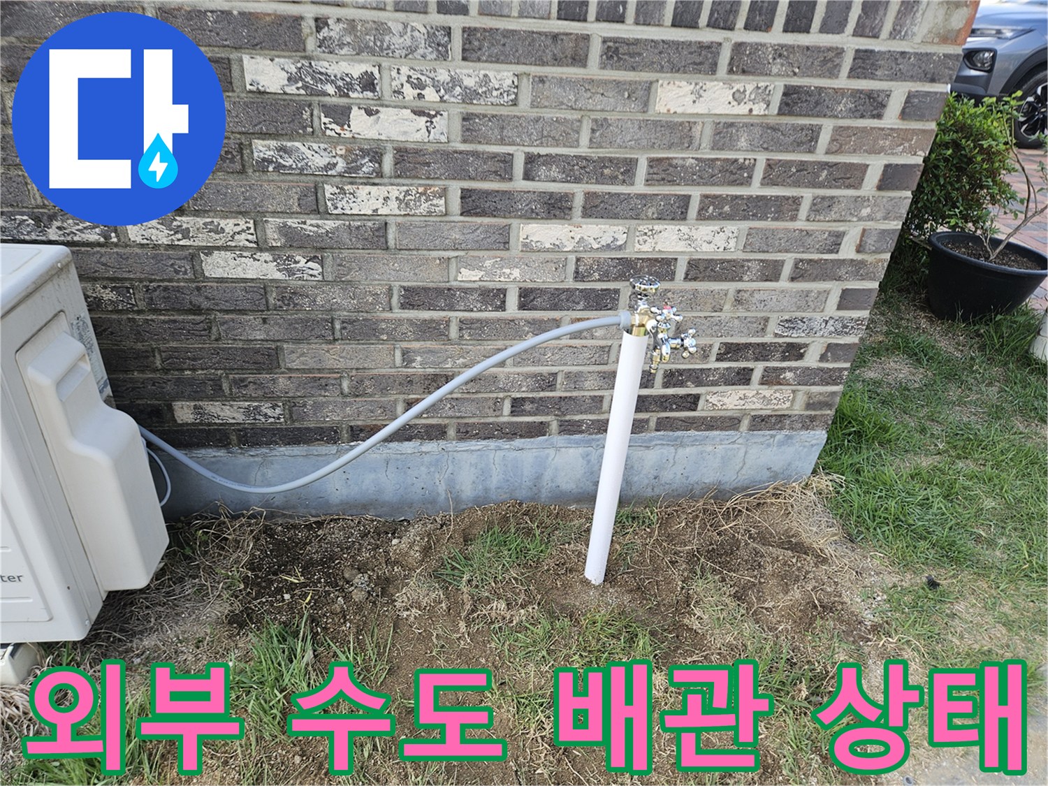 벽돌 외벽에 설치된 외부 수도꼭지와 연결 배관 모습