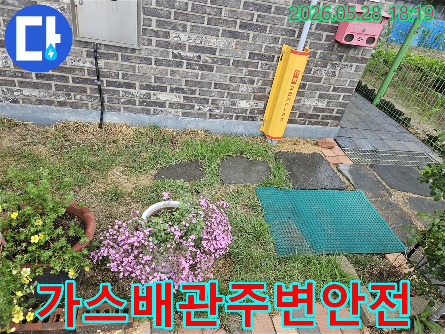 주택-외벽에-설치된-노란색-가스배관-보호대와-그-주변의-지면-상태