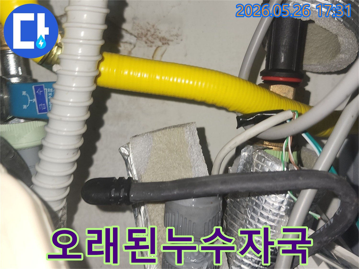 이것은 보일러 또는 온수기 주변의 배관 설비 모습으로-누수로 인해 벽에 생긴 물자국이 확인됩니다-정밀한 탐지가 요구되는 현장입니다