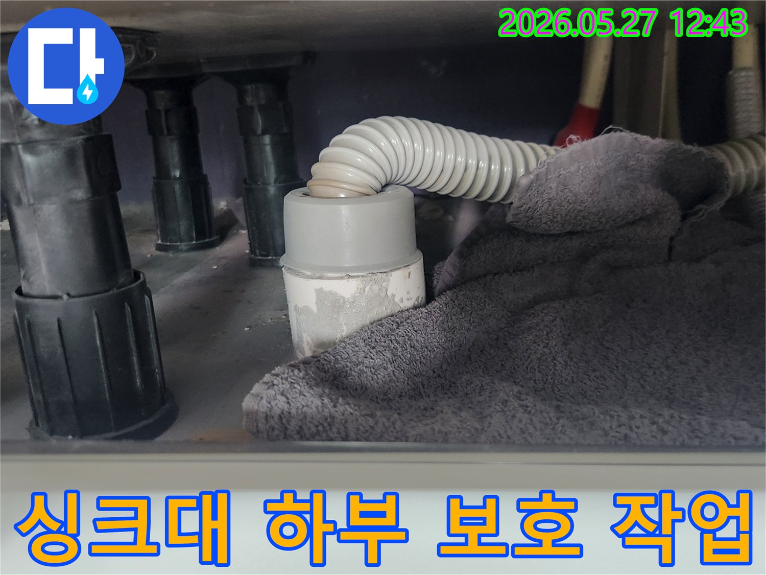 싱크대 배관 작업 전-하부 공간을 보호하고-이물질 유입을 차단하기 위해-수건을 놓아둔 모습입니다