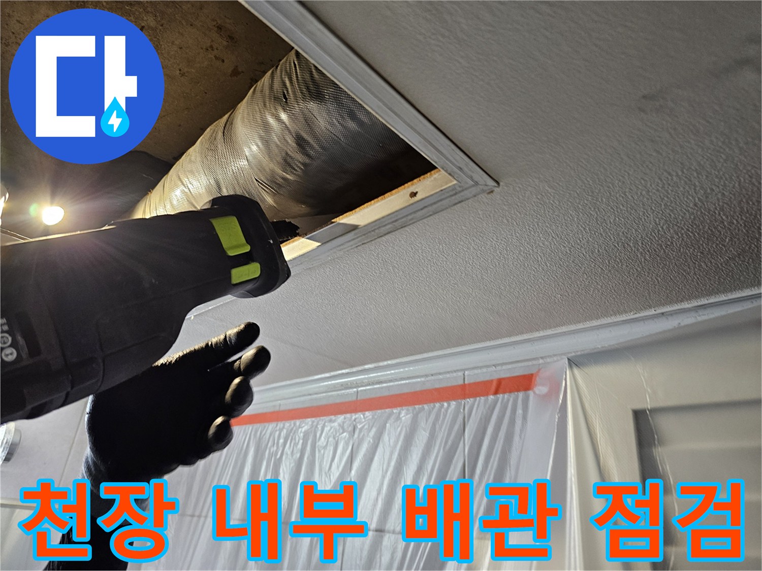 전동 공구를 사용하여 천장 안쪽의 노후된 배관을 확인하고 있습니다.