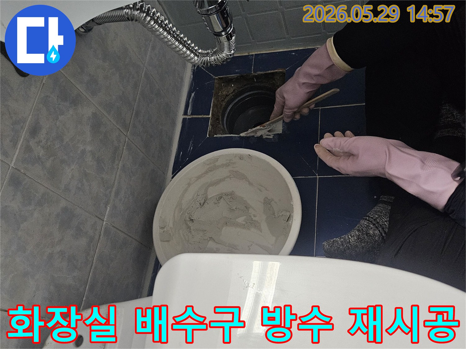 누수 전문가가-화장실 바닥 배수구 주변의-방수층을 꼼꼼하게 재시공하는 모습