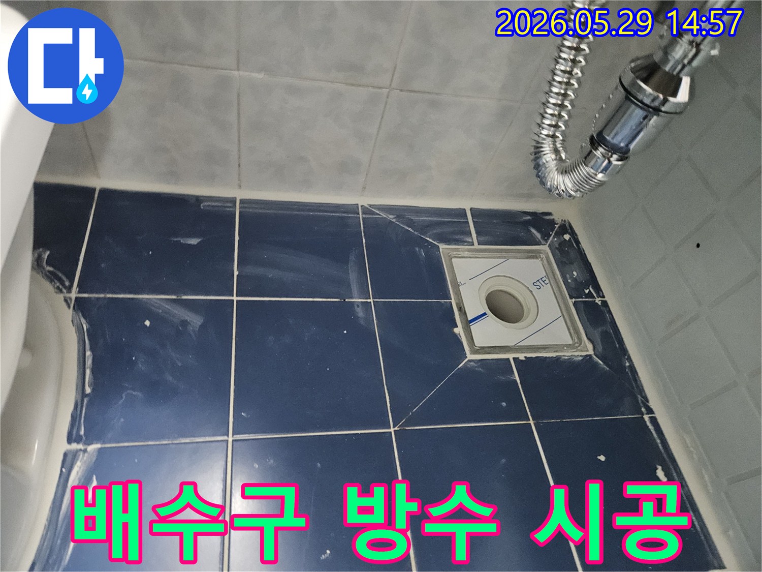 욕실 바닥에-새로운 배수구가-설치되고-주변 타일과-배수관이-정돈된-누수-방지-작업-현장-사진입니다