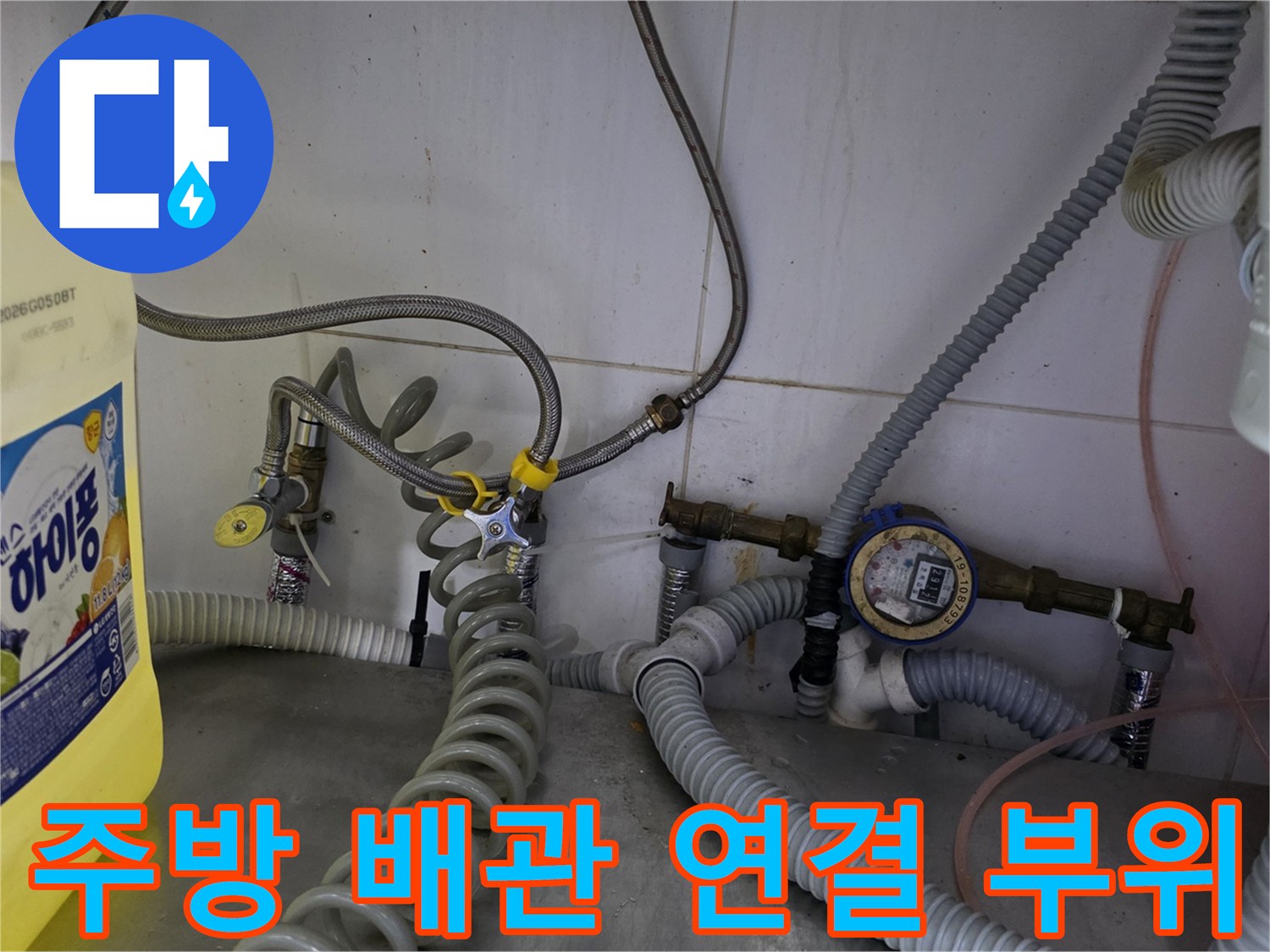 식당 주방 하단-복잡하게 얽힌 수도 배관과 계량기 모습