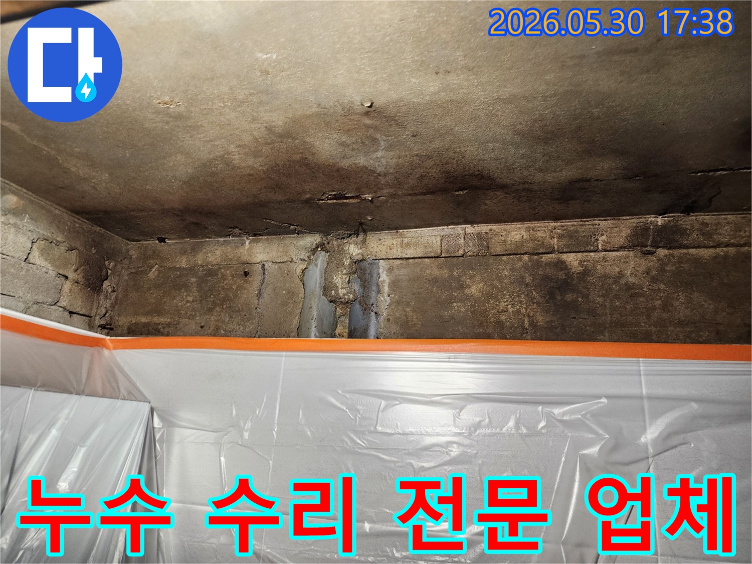 천장과 벽의 손상된 부분에서-누수 수리 전문 업체가-현장을 점검하는 모습