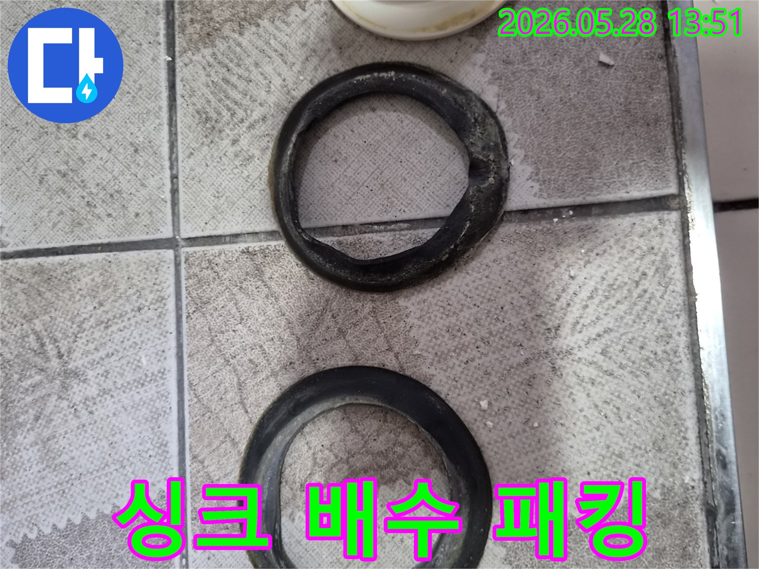 싱크대-배수관에서-누수를-유발하는-오래되고-경화된-고무-패킹의-손상된-모습을-보여줍니다.