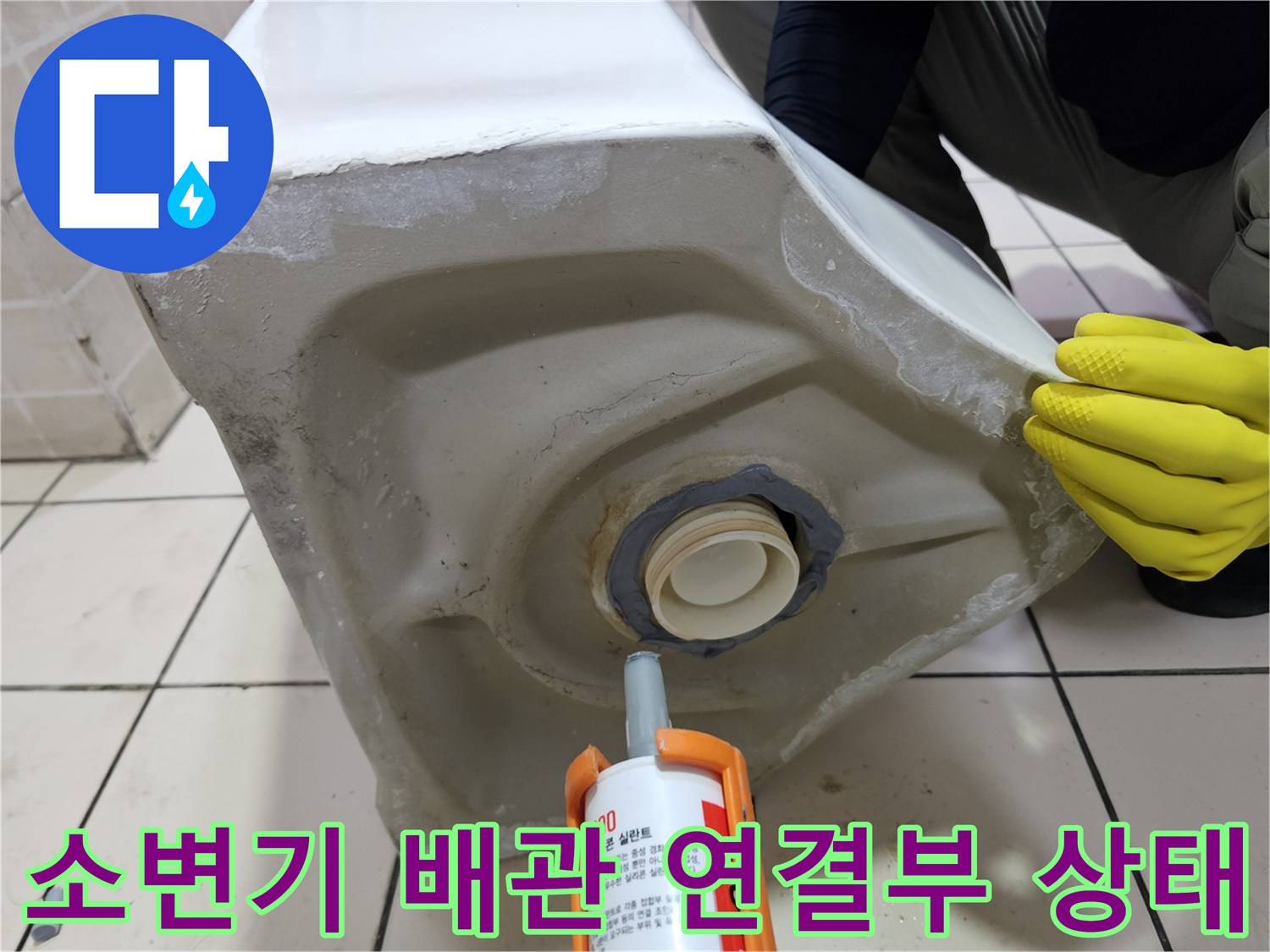 탈거된 소변기의 하단 배관 연결 부위와 실리콘 마감재 모습