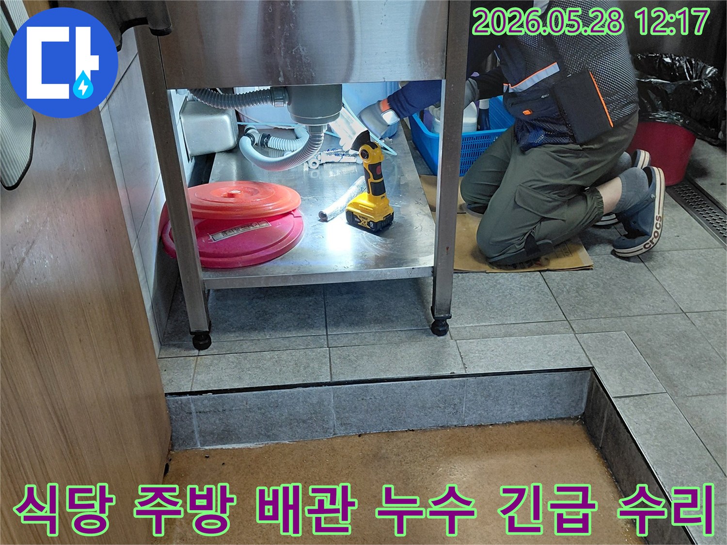 이 이미지는-긴급 상황에서-전문 엔지니어가-식당 주방의-배관 누수를-신속하게-방문하여-처리하는-모습을-보여줍니다
