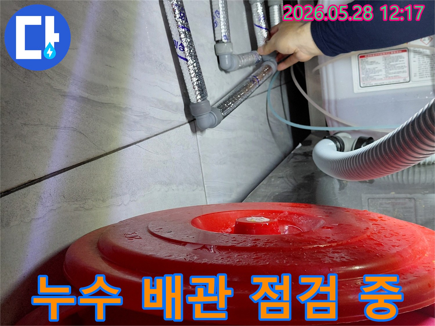 전문 엔지니어가-젖은 바닥과-배관 연결부를-꼼꼼히 점검하며-누수 원인을-찾고 있습니다.