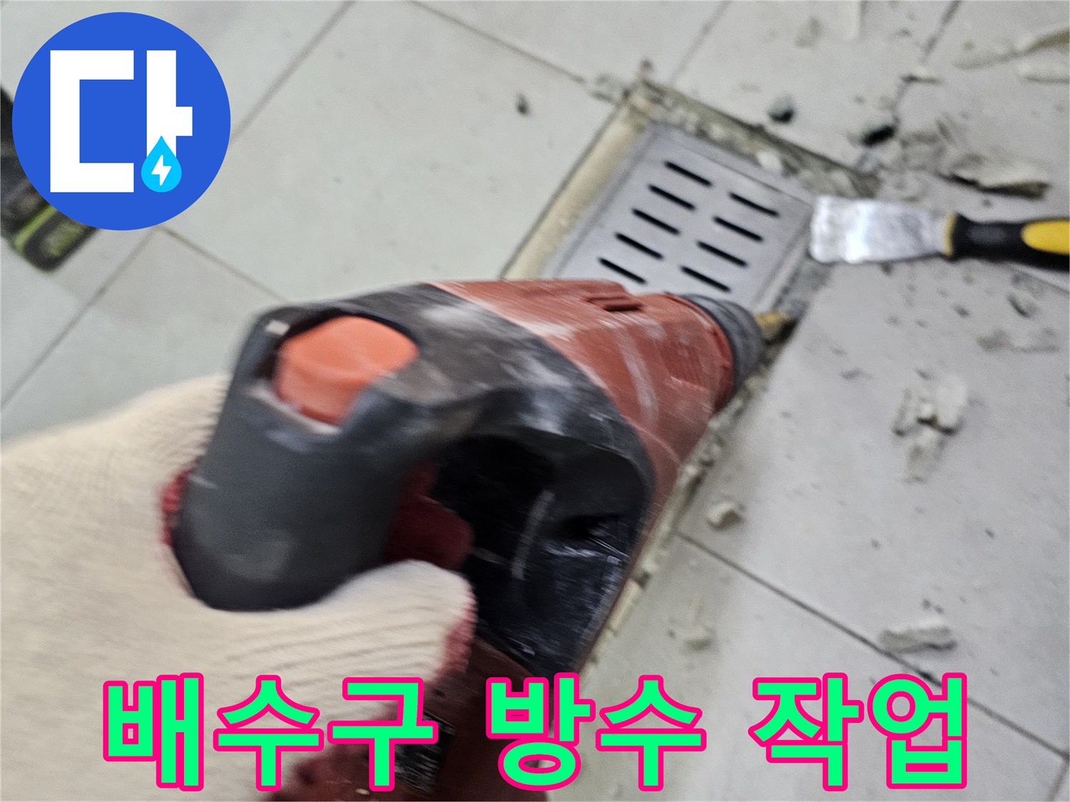 함마드릴을 사용하여 트렌치 주변 타일을 제거하는 공사 장면