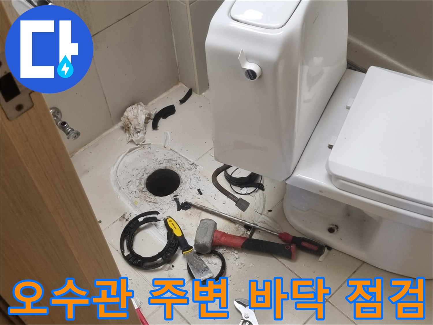 변기 하부 배관 입구와 주변 타일 마감 상태를 확인하는 작업 장면