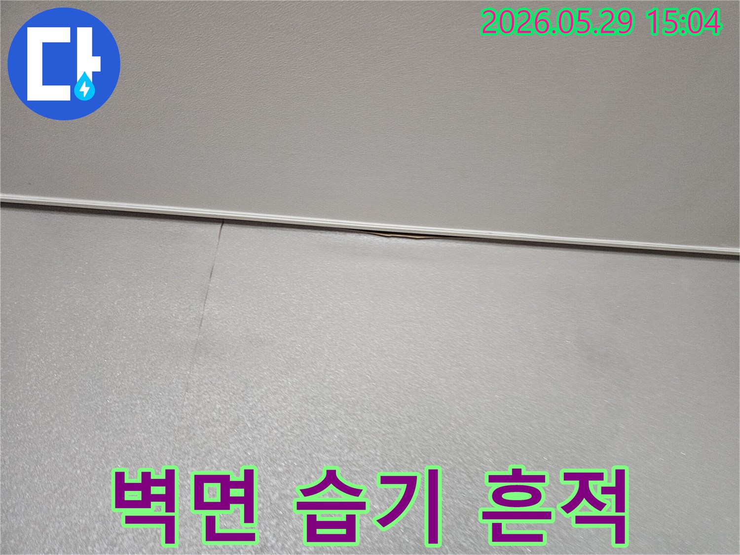아파트 벽면 상단-모서리에 나타난-습기 흔적과 미세 균열로-누수가 의심되는-초기 상황을 보여주는 이미지